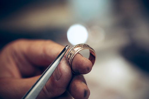Jeweler Settings Diamonds Into Gold Ring