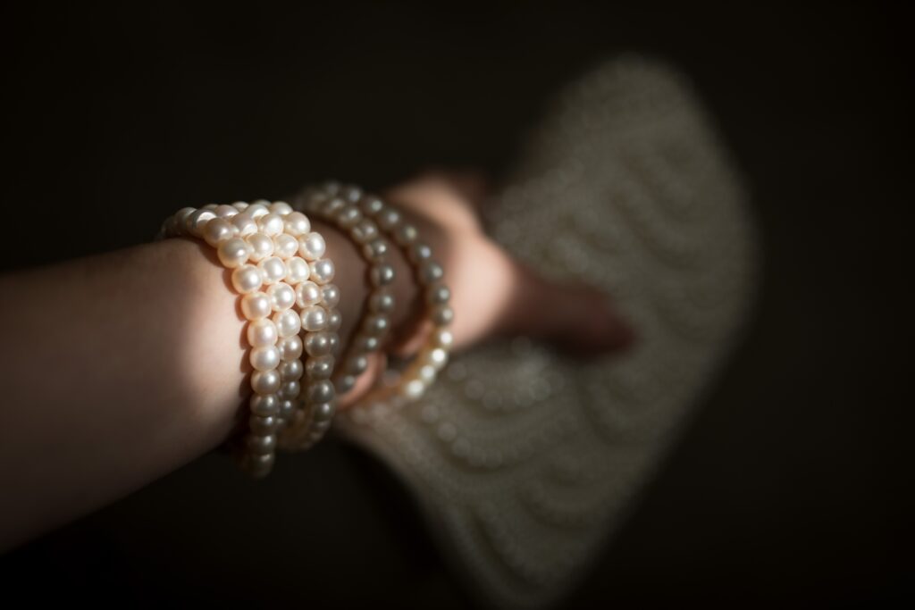 pearl bracelet on woman's wrist holding a clutch