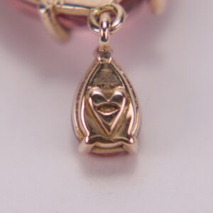Gold heart-shaped pendant with intricate design.