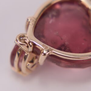 Gold pendant with a red gemstone.