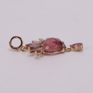 Pink gemstone charm with gold setting.