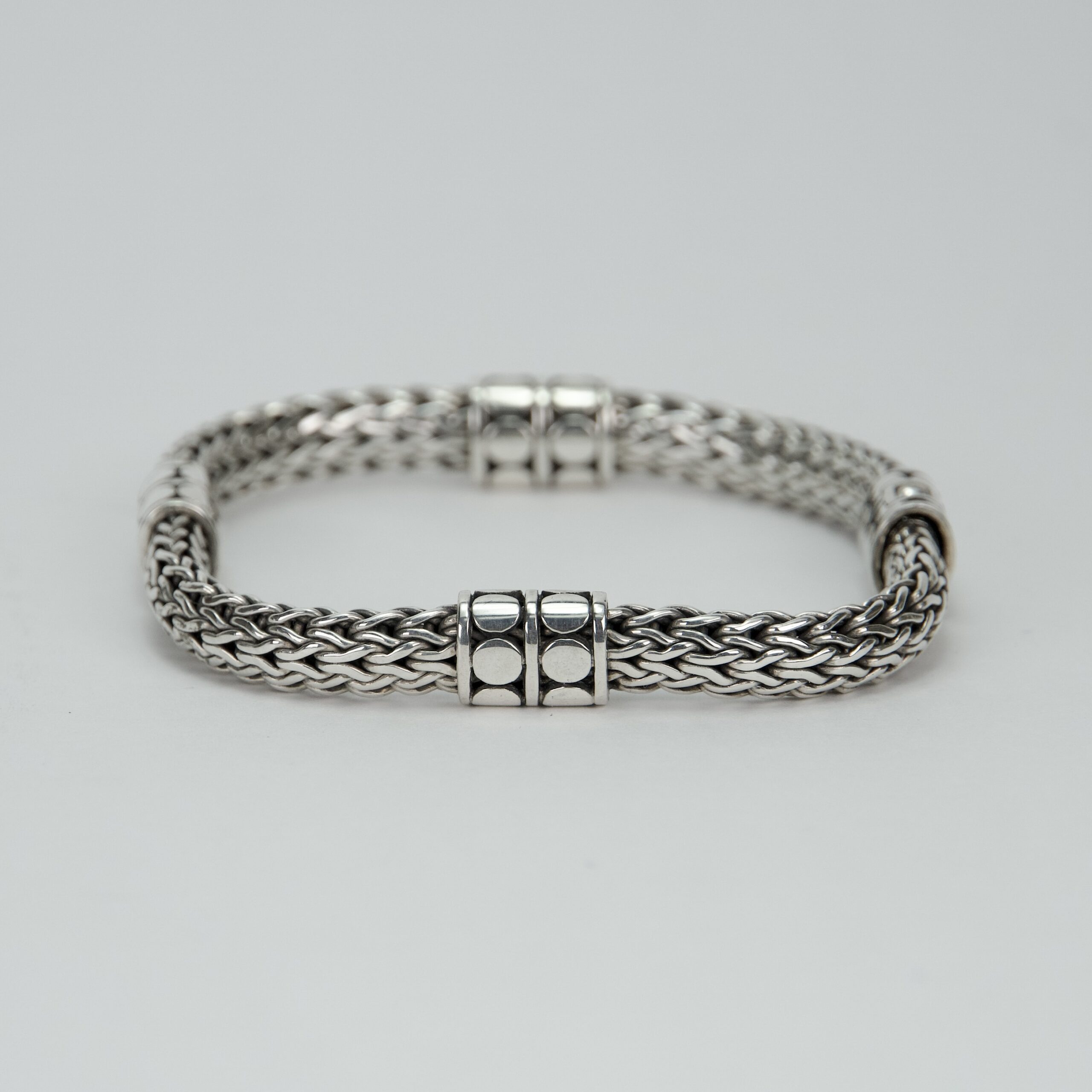 Silver woven bracelet with clasp details.
