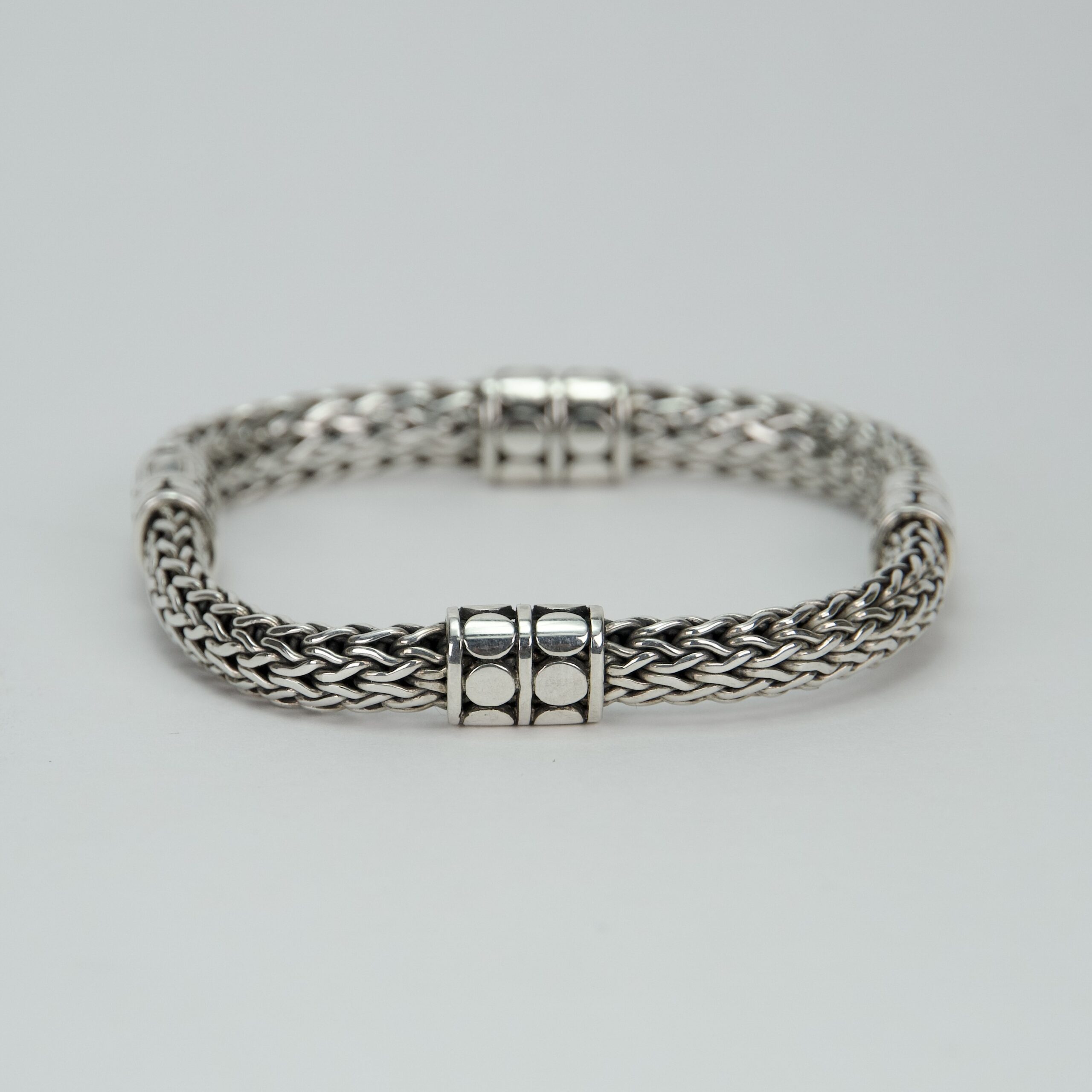 Silver braided bracelet with decorative clasps.