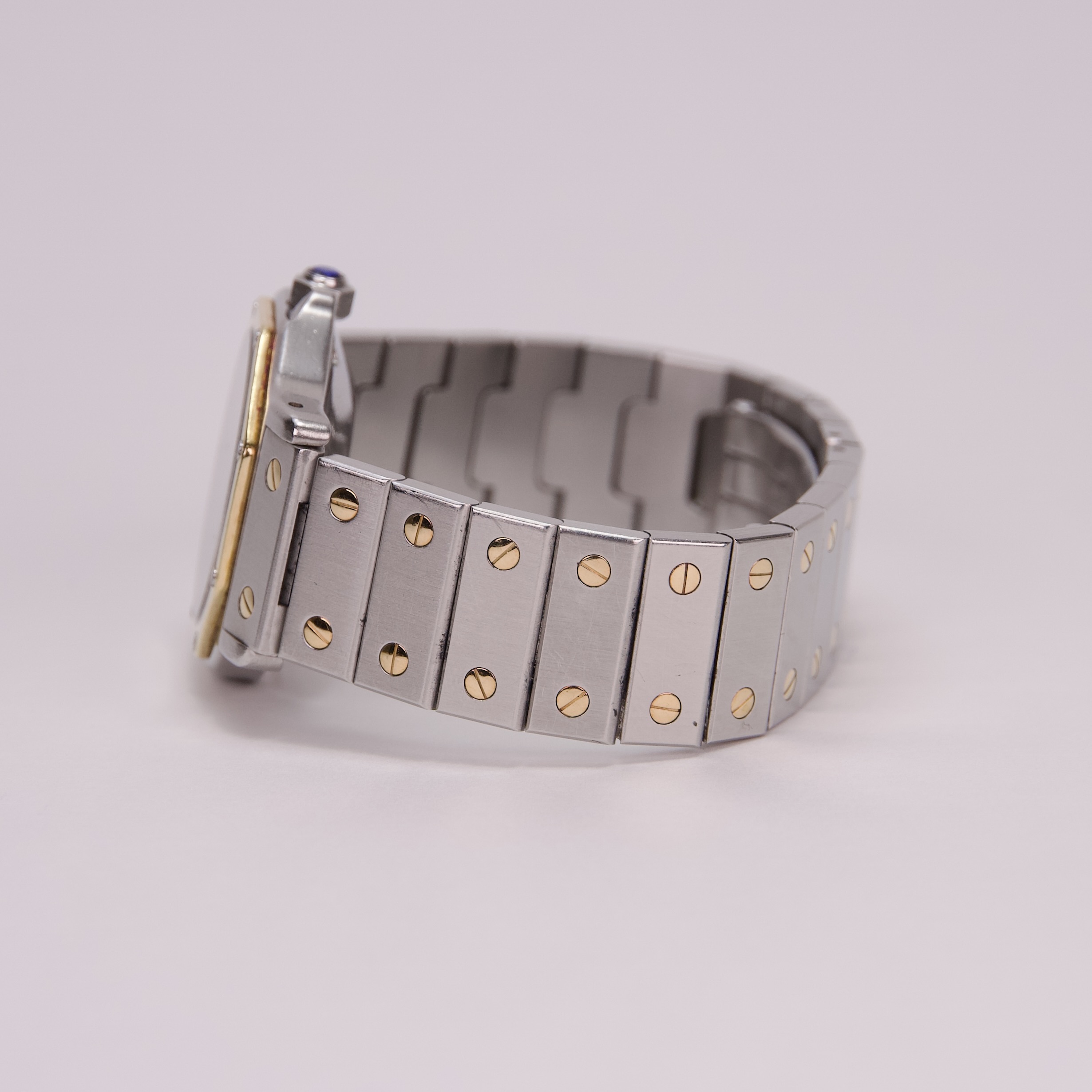 Silver watch band with gold screw details.