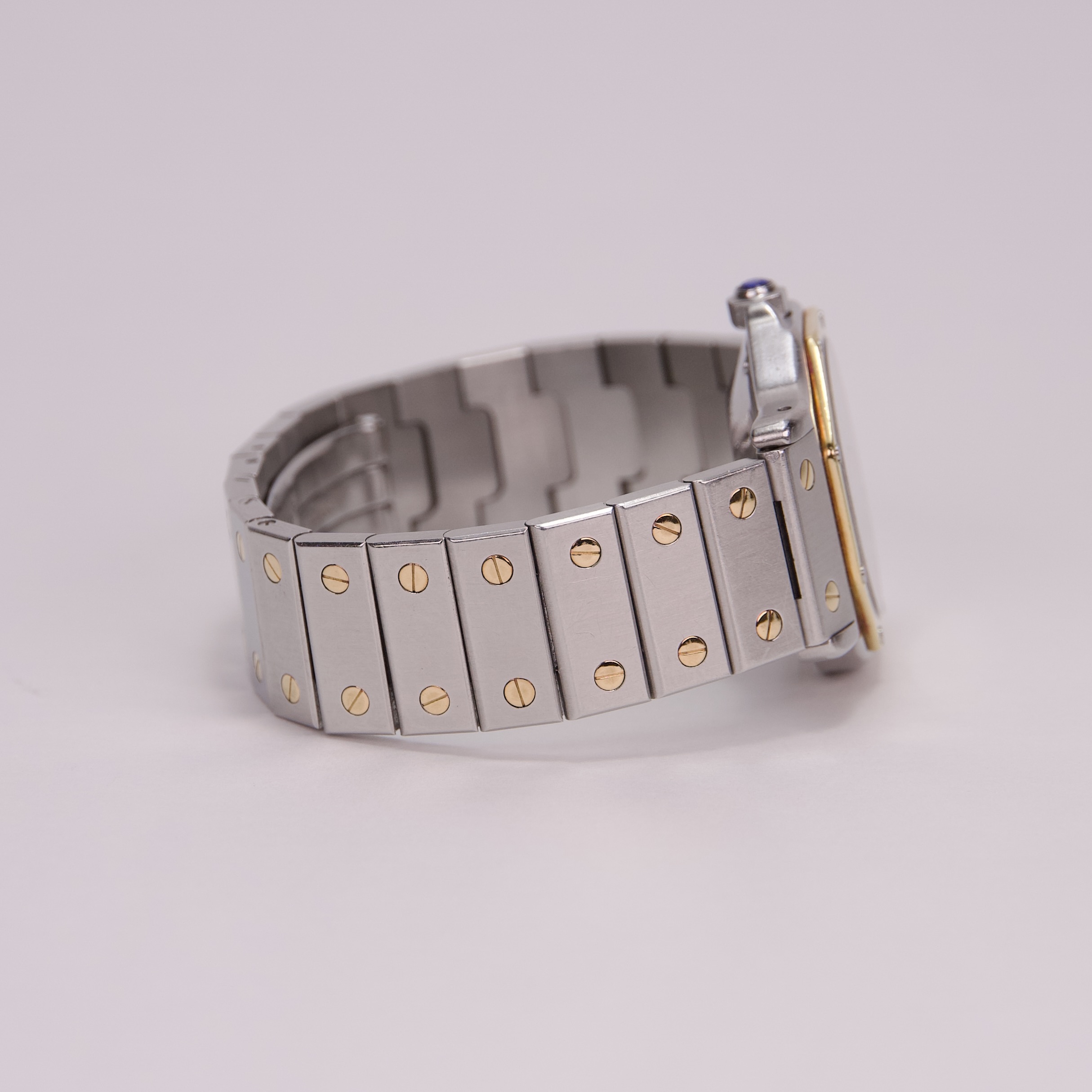 Silver watch with gold accents, side view.