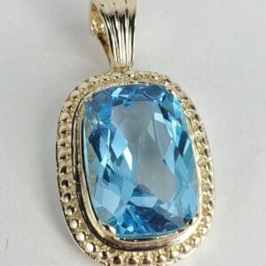 Blue gemstone pendant with gold setting.