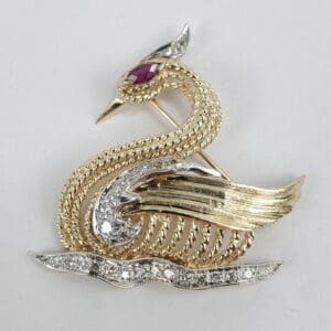 Gold and silver bird brooch with gemstones.